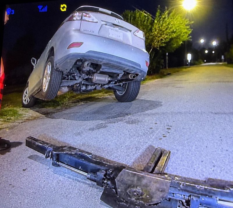 A silver car being winched out of a ditch at night with a tow truck visible, showcasing Turbo Tows emergency winch out and towing service in Houston.