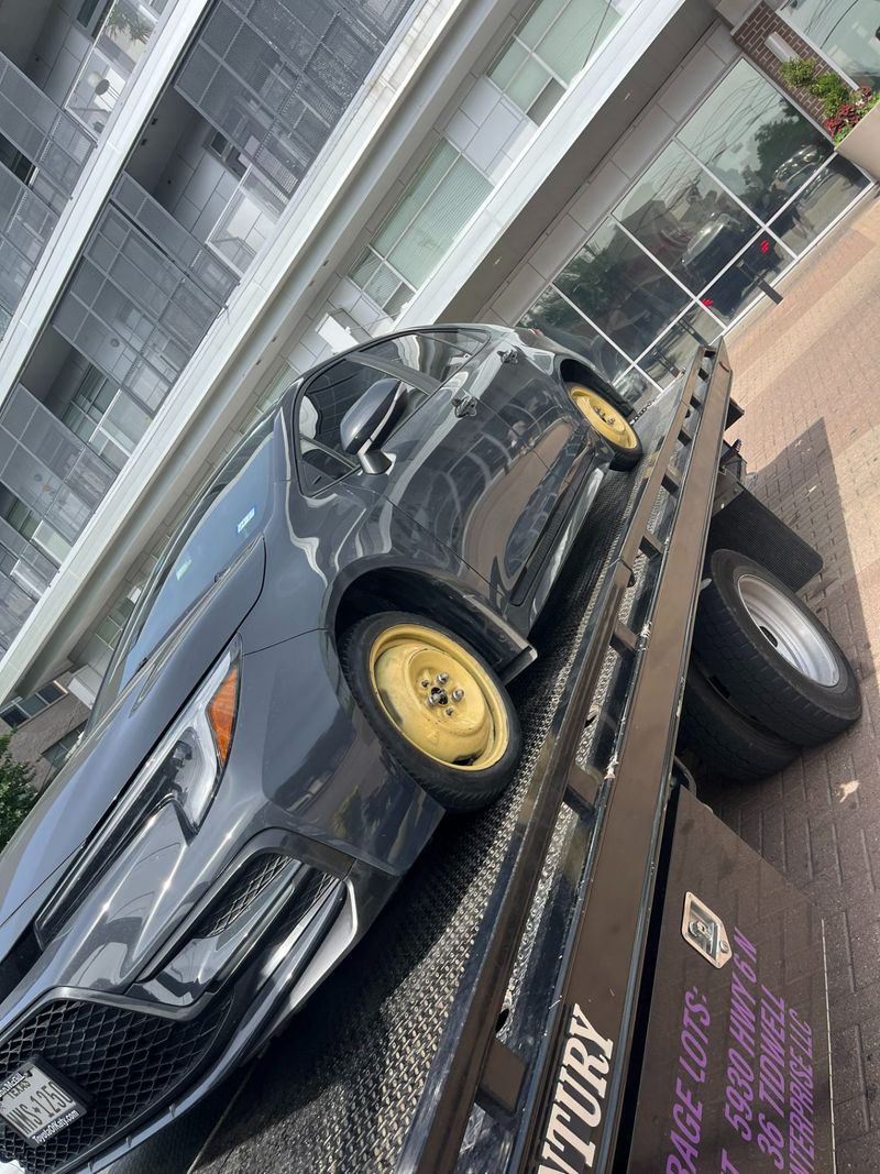 Car loaded on a tow truck at residential location in Houston.
