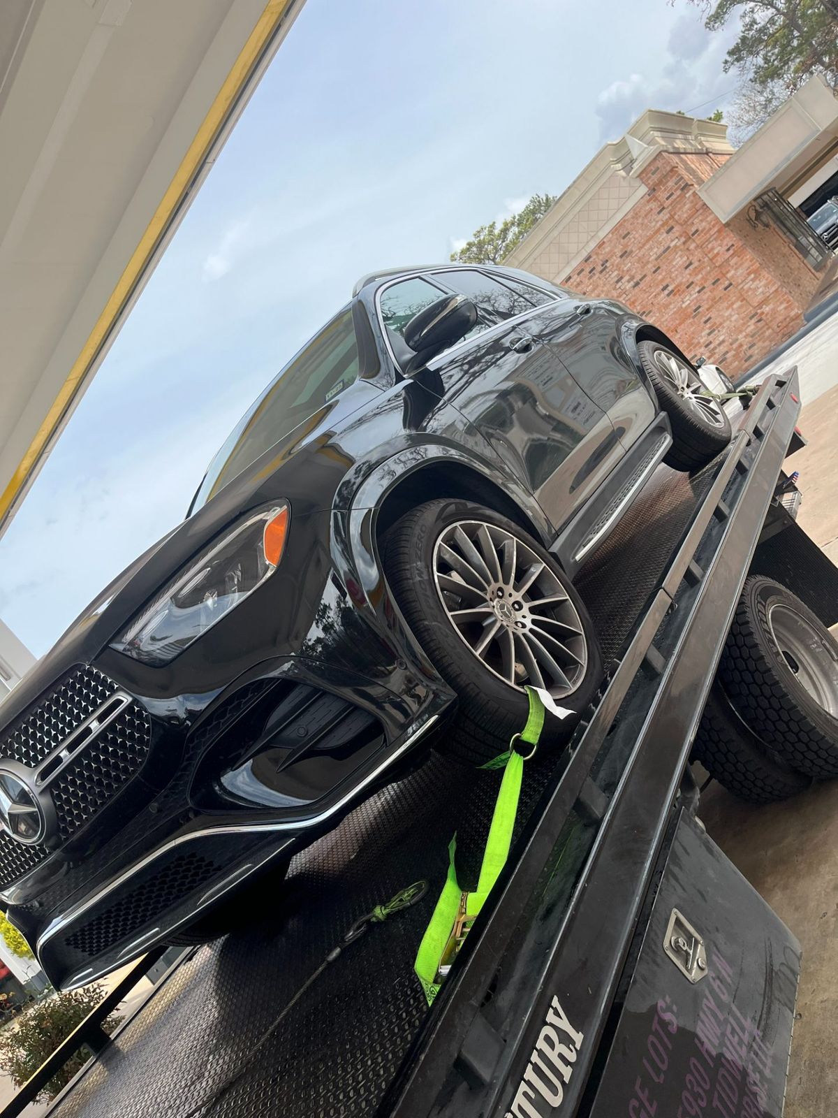Black luxury Mercedes SUV on a flatbed tow truck, ready for transport